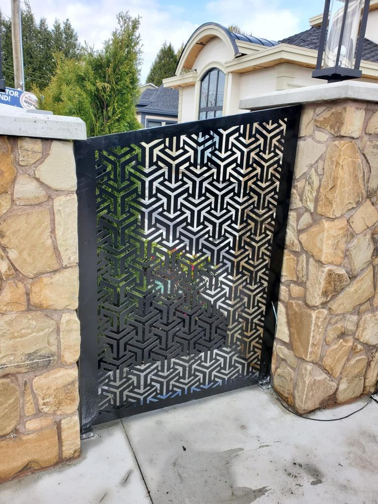 Laser-cut geometric steel gate between stone pillars